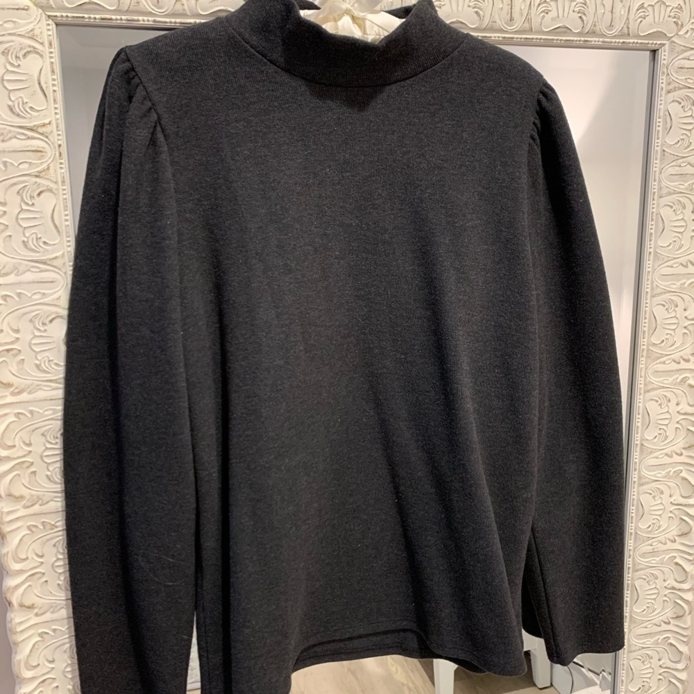 Black turtleneck with tailored neck. Custom tucks on shoulders.